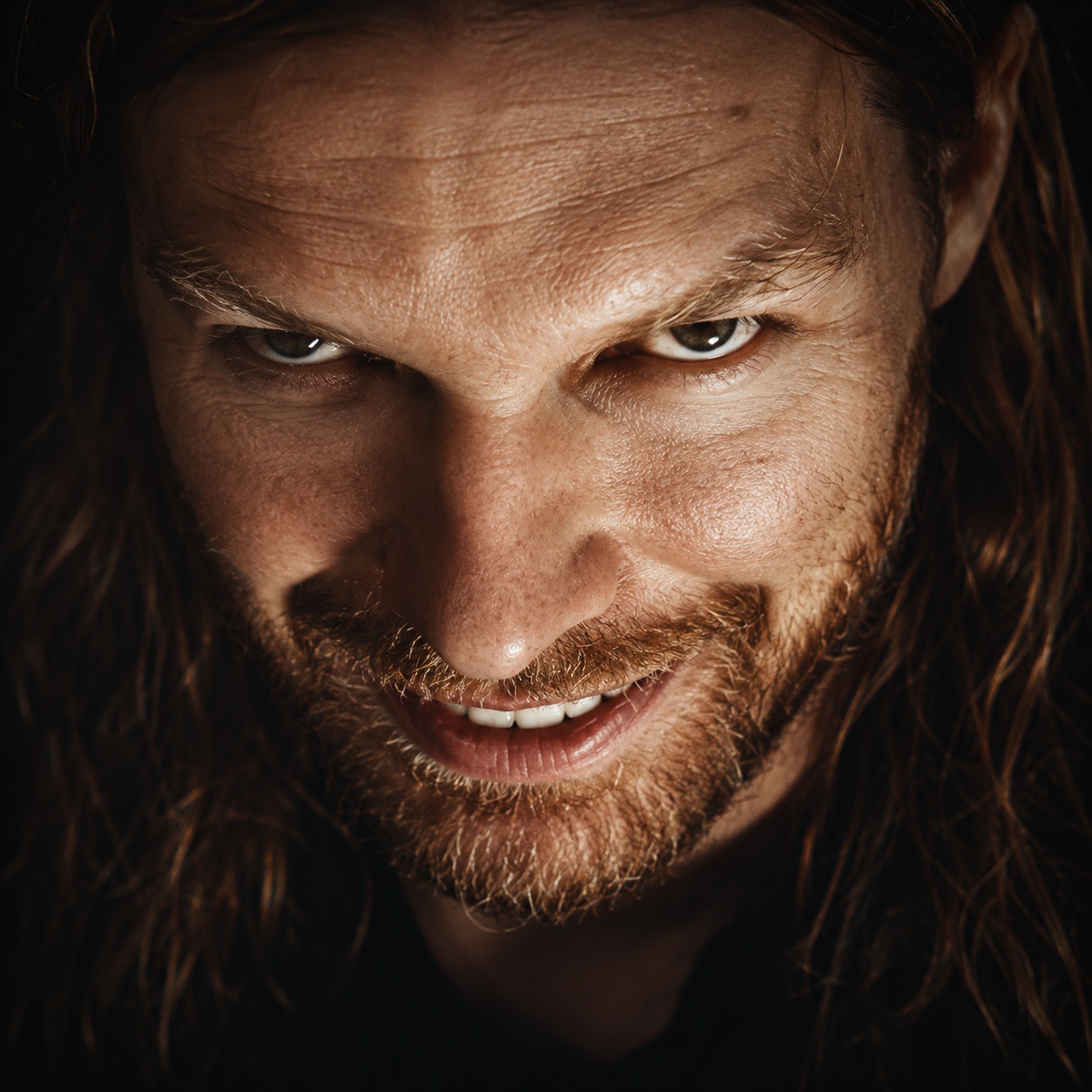 Richard D. James alias Aphex Twin in einem düsteren Porträt mit verschmitztem Blick